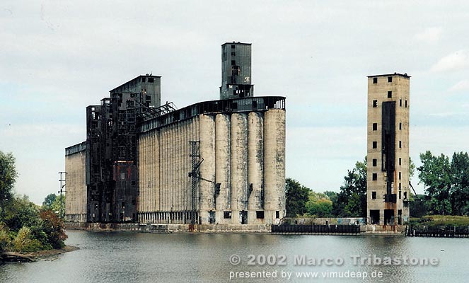 Wasserseite. Wasserseite des Concrete Central Elevator gegen den Buffalo River. Rechts vom Getreidesilo steht ein fester Seeausleger-Turm in Eisenbeton, dazwischen der Förderbandkanal.