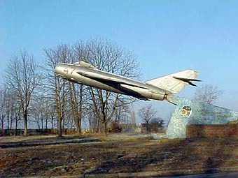 Abflug. Zurückgelassenes MIG Jagdflugzeug MIG 15 mit ausgebautem Triebwerk und aufgespießt auf einen Halteträger. Leider sind eine ganze Reihe Gebäude auf dem Flugplatz schon verschwunden, weil es da angeblich keine Verwendung für gab.